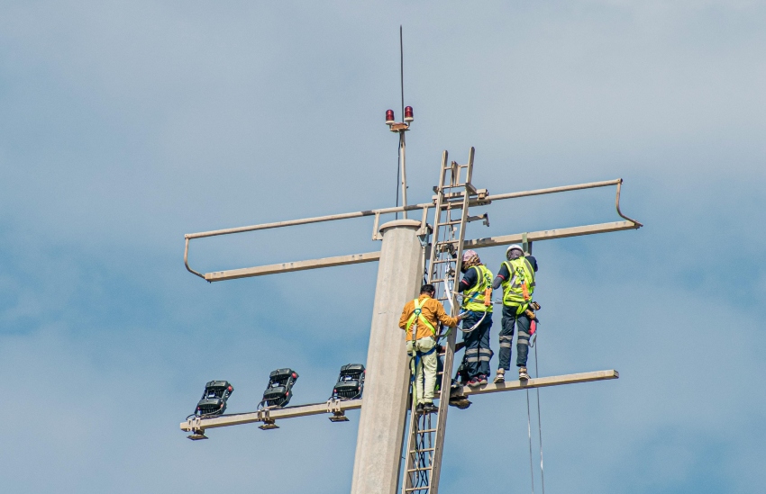 tradespeople wearing hivis working at height on tall ladder - maximum working height for ladders