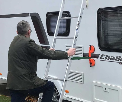 man climbing ladder on caravan