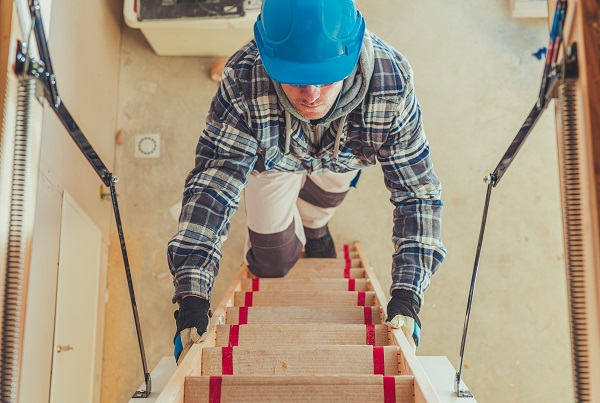 worker climbing on loft ladder