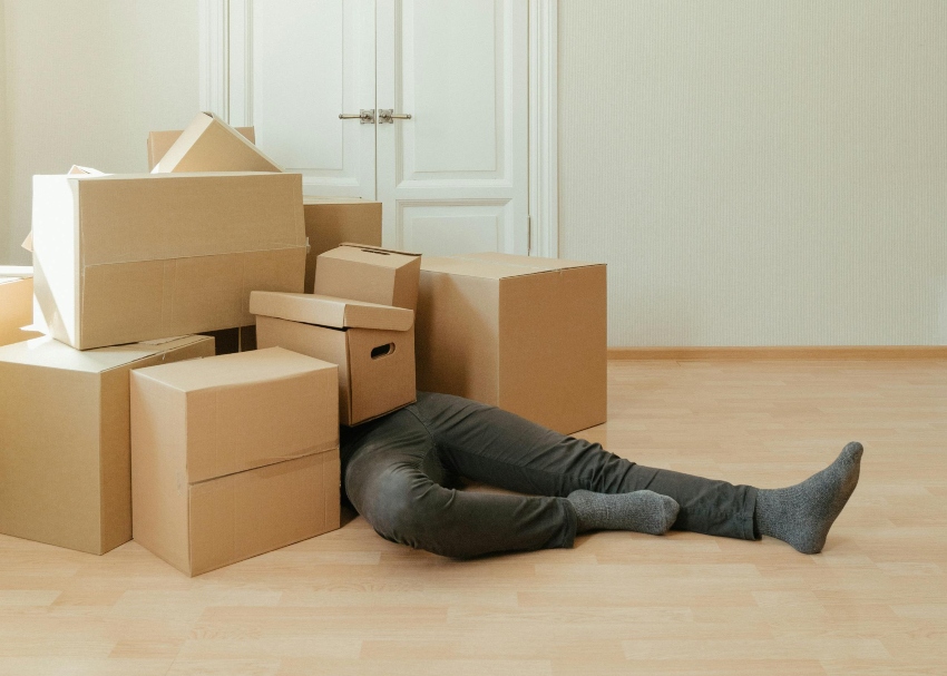 man lying under pile of boxes after a fall - most common ladder accidents