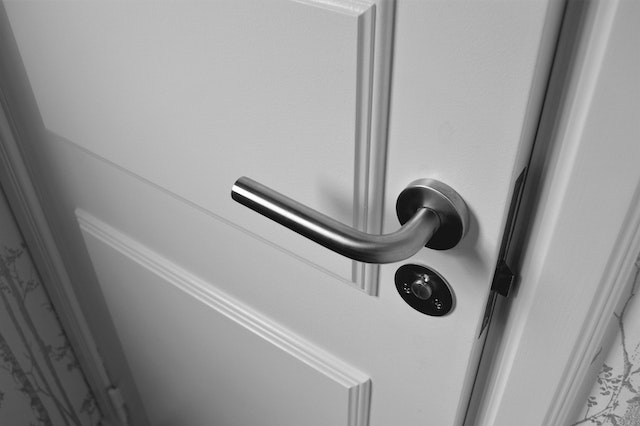 diy tips all homeowners should know - tightening a door handle - silver door handle on white door