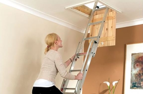 Person climbing a sliding ladder to acces the loft