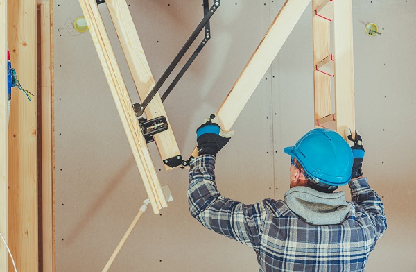 Handyman using a loft ladder