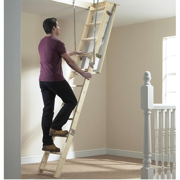 Man climbing up a wooden loft ladder
